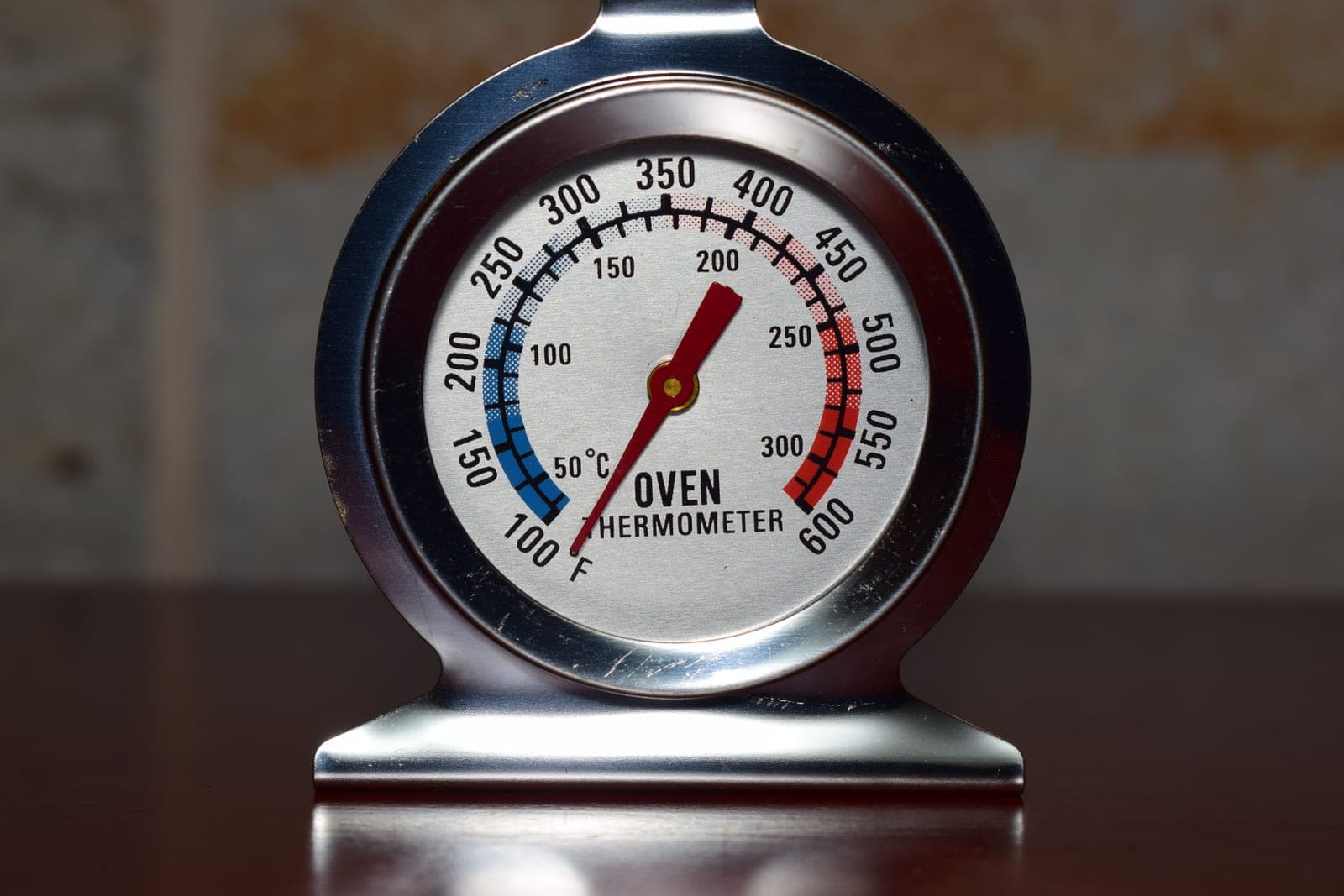 A round analog temperature gauge with a black needle